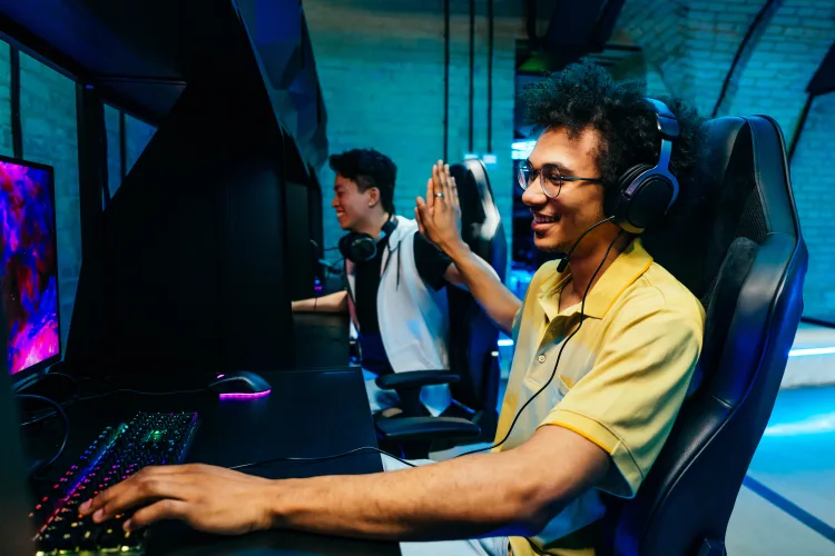 gamer playing video games while hi-fiving a fellow gamer